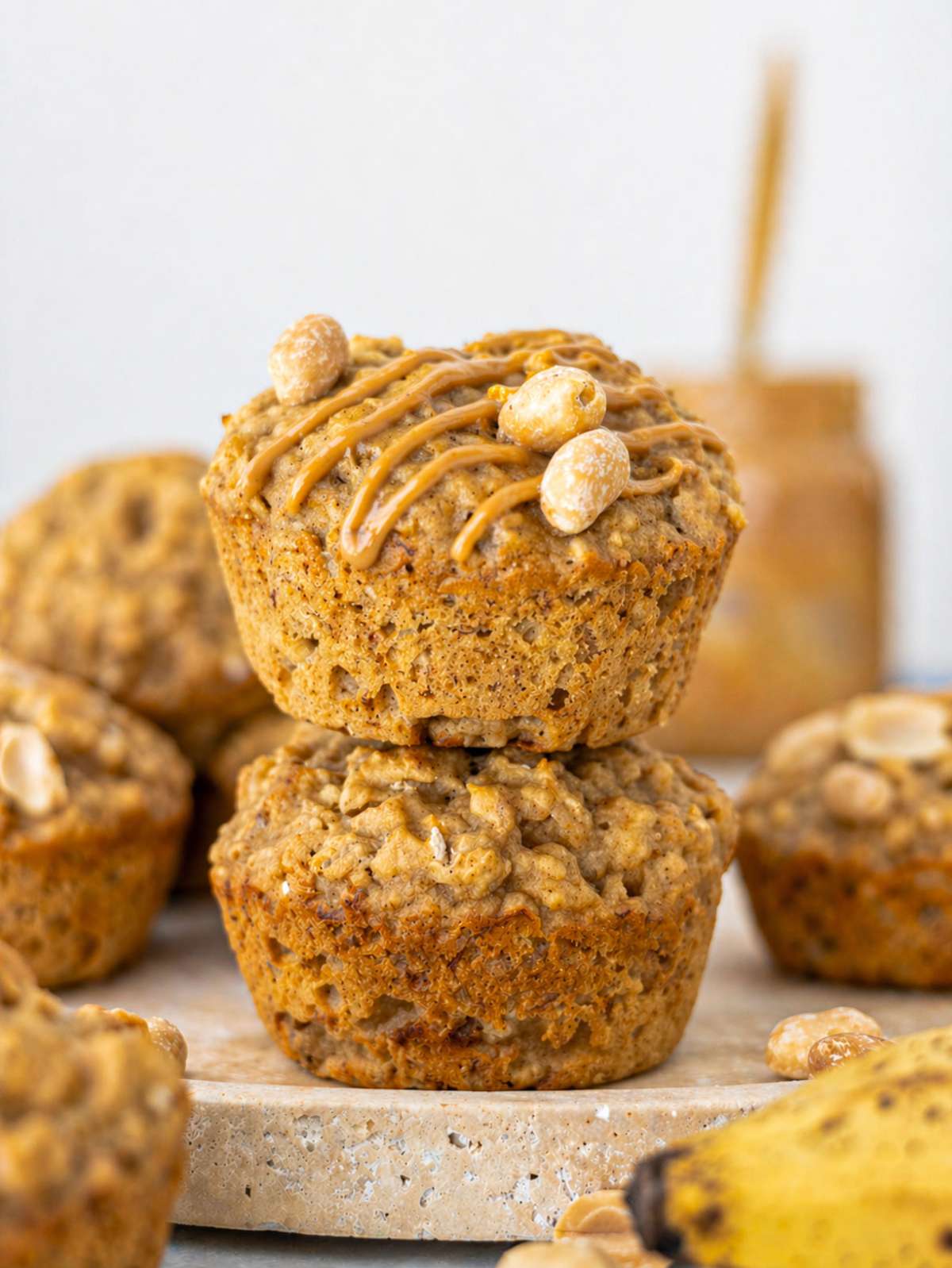 Peanut butter banana muffins on marble table showing golden tops.
