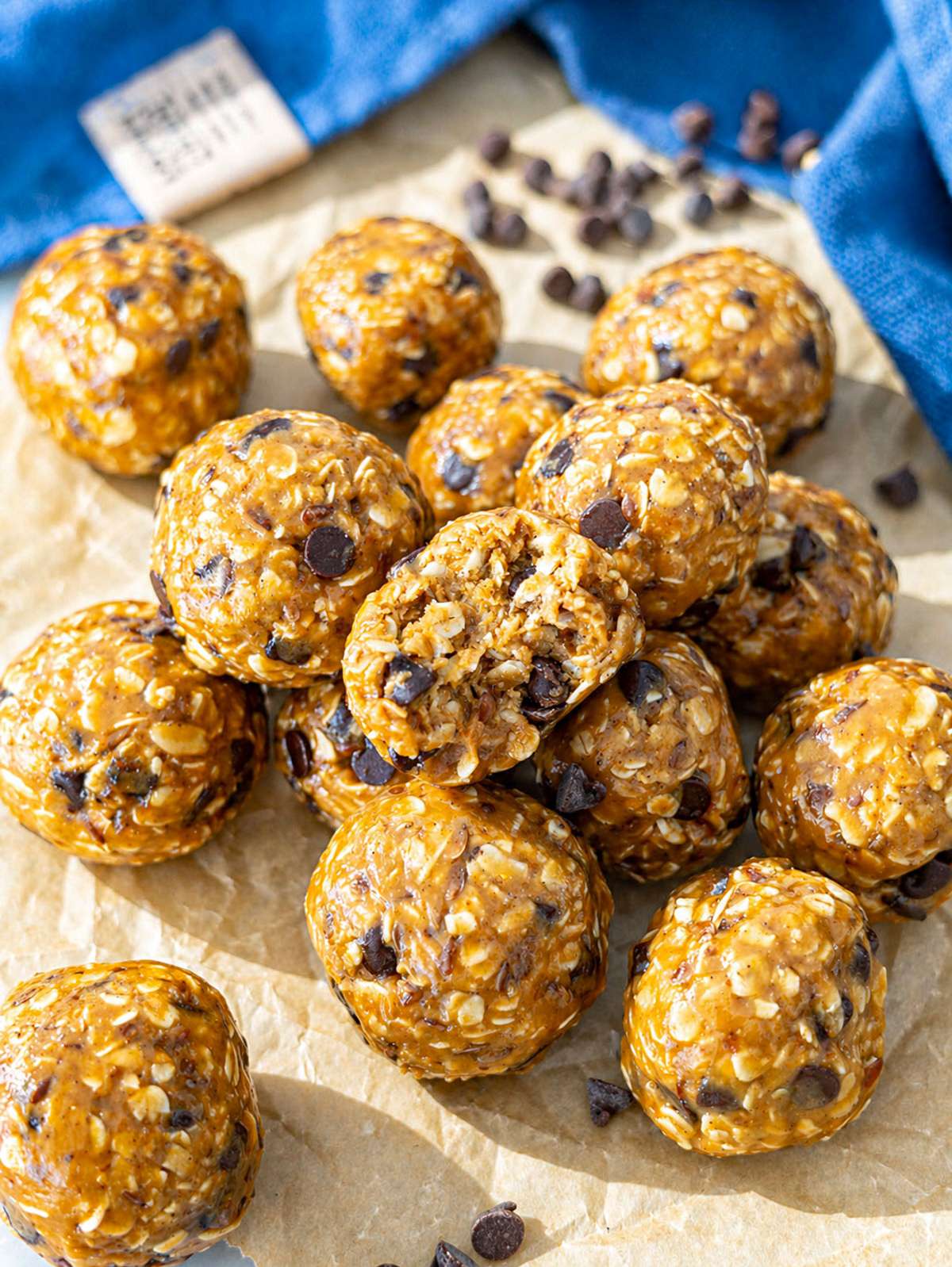 Peanut butter energy balls stacked in a bowl near a bright window.