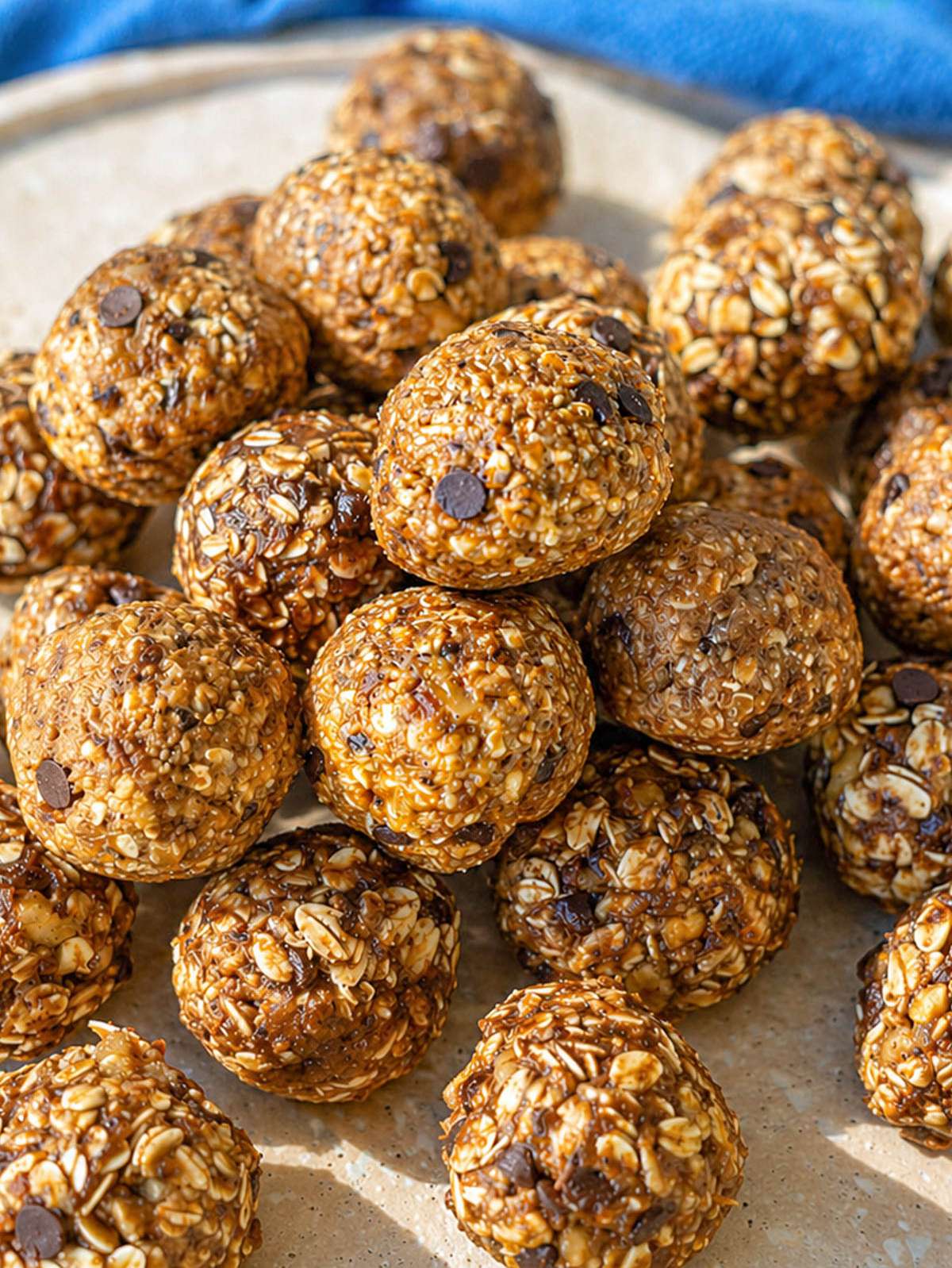 Plate of banana bread energy balls on marble table, soft light from window.