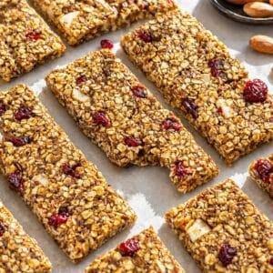 Soft and chewy no bake oat bars with nuts, seeds, and cranberries on a marble countertop.