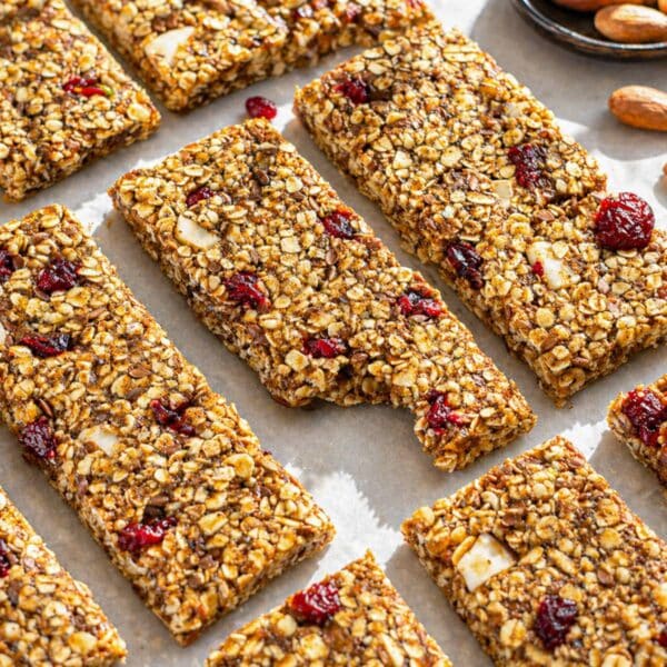 Soft and chewy no bake oat bars with nuts, seeds, and cranberries on a marble countertop.