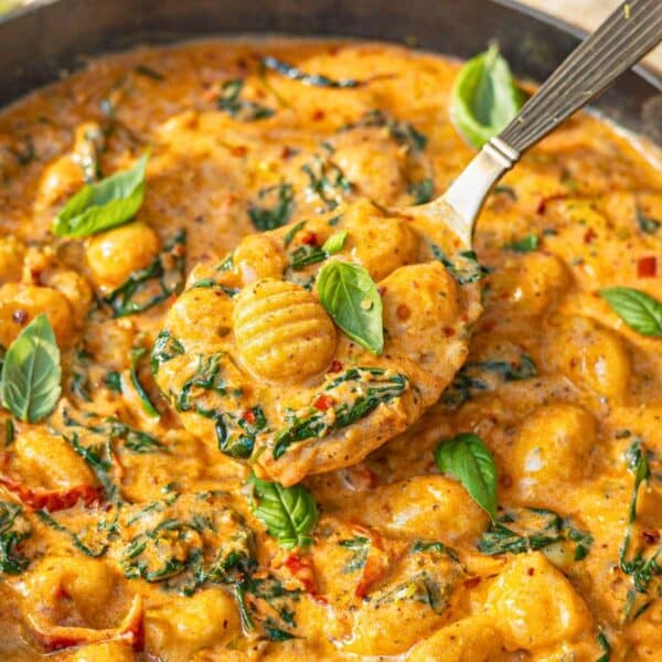 Spoon lifting creamy marry me gnocchi showing soft texture and rich sauce with spinach.