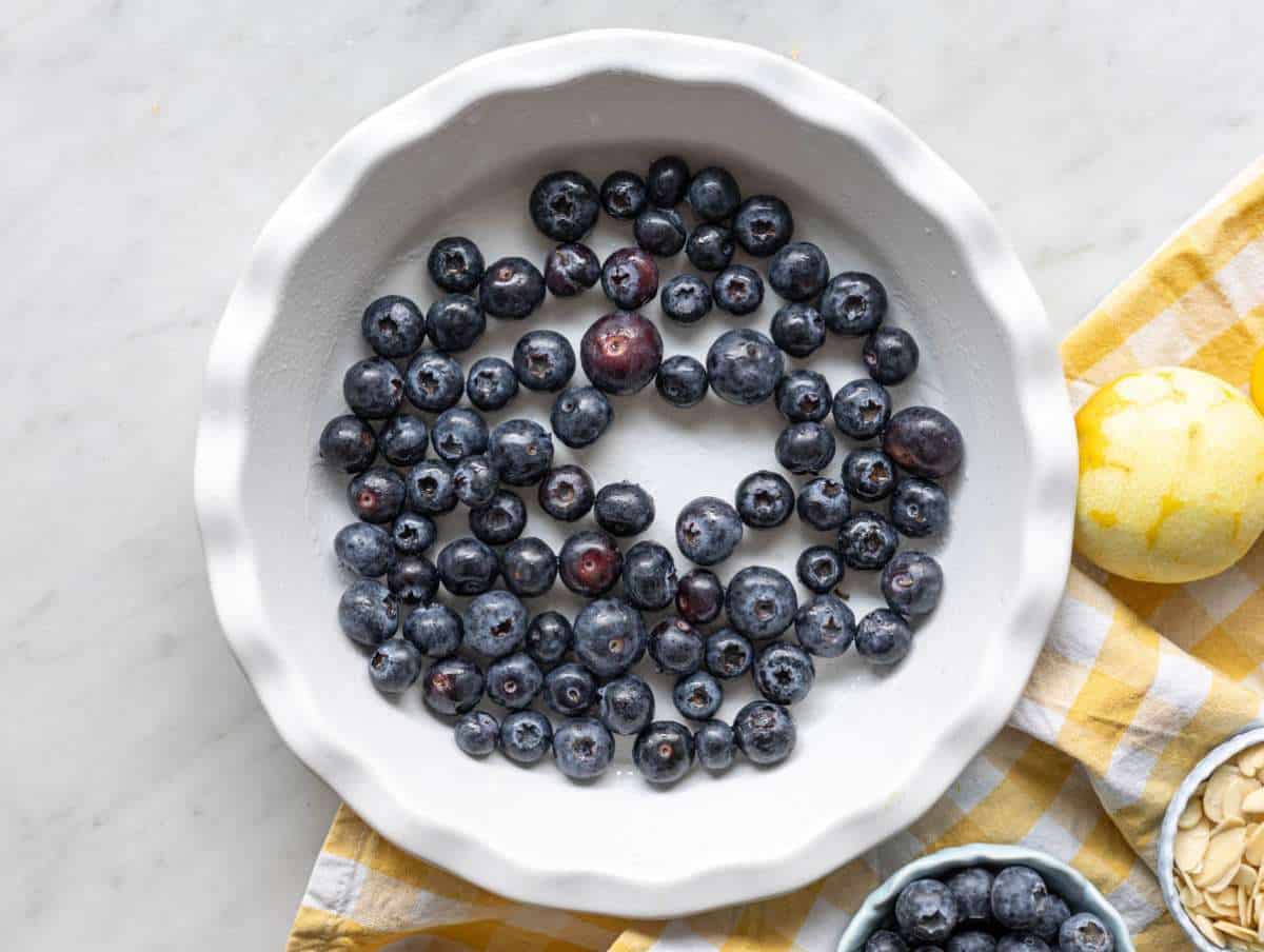 Step 1 Blueberries spread in a greased baking dish before adding the batter.