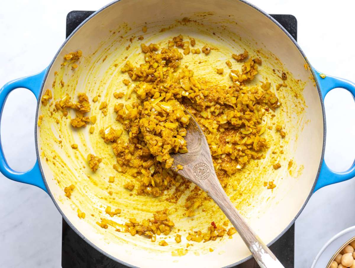 Step 1 Chopped onion cooking in olive oil in pot on stovetop.