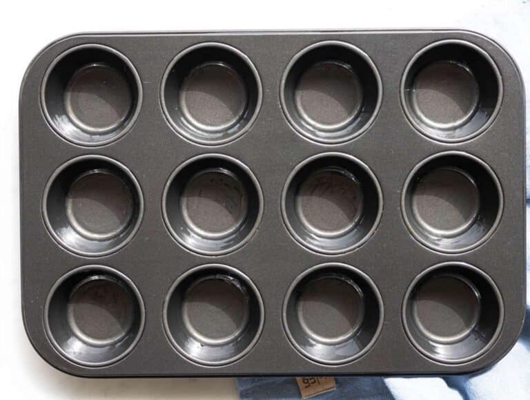 Step 1 Greased muffin pan on marble surface ready for baking.