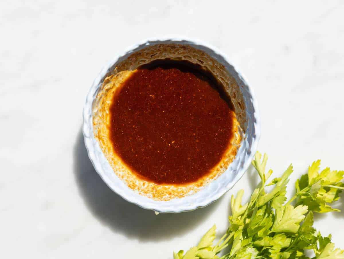 Step 1 Mixing shawarma spices with olive oil and garlic in small bowl on marble surface.