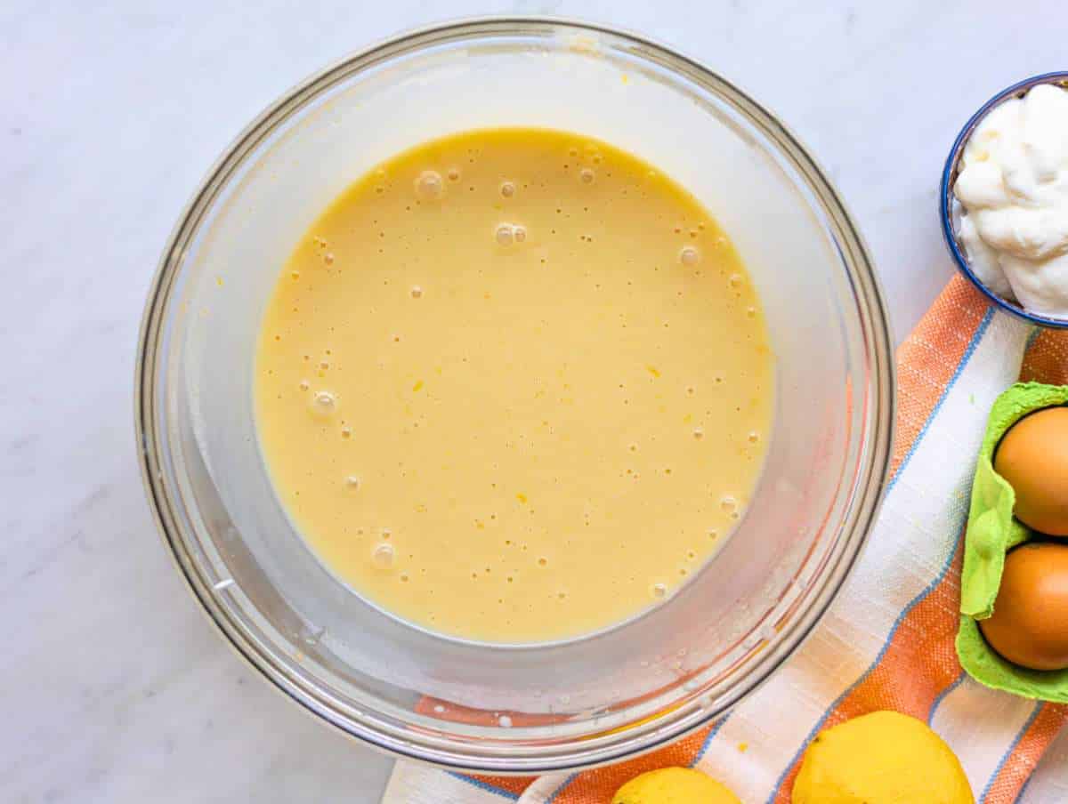 Step 1 Whisking egg yogurt and lemon mixture in bowl near window light.