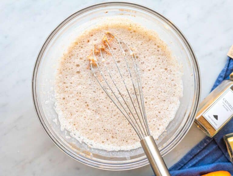 Step 2 Grated carrots and raisins being stirred into creamy oat mixture in bowl.