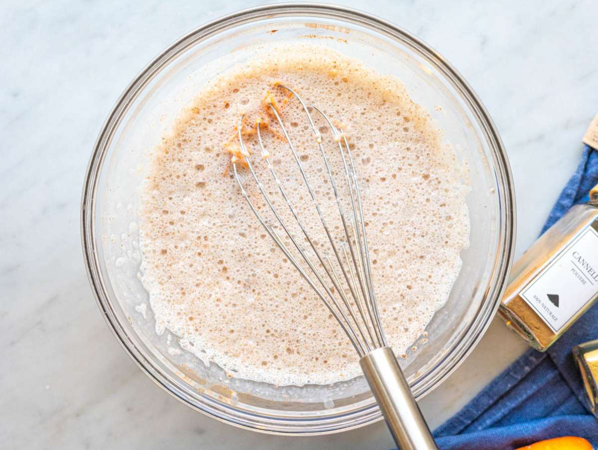 Step 2 Grated carrots and raisins being stirred into creamy oat mixture in bowl.
