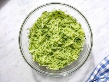 Step 2 Grated cucumber being squeezed by hand to remove excess moisture.