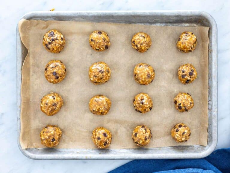 Step 3 energy balls rolled and placed on a tray with parchment paper.