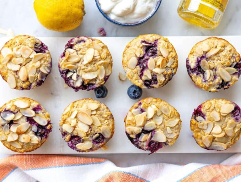 Step 4 Baked oatmeal cups cooling on marble table with golden tops.