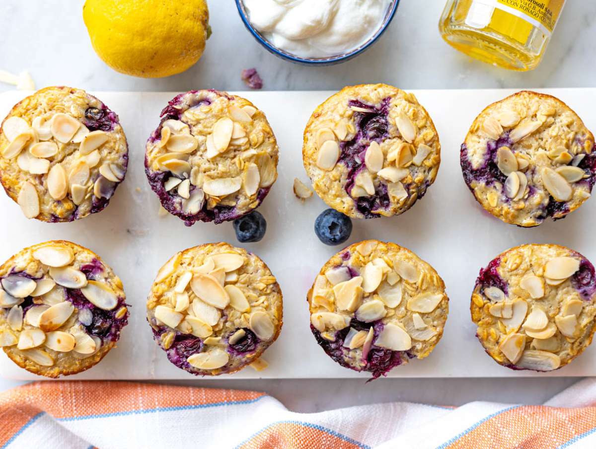 Step 4 Baked oatmeal cups cooling on marble table with golden tops.