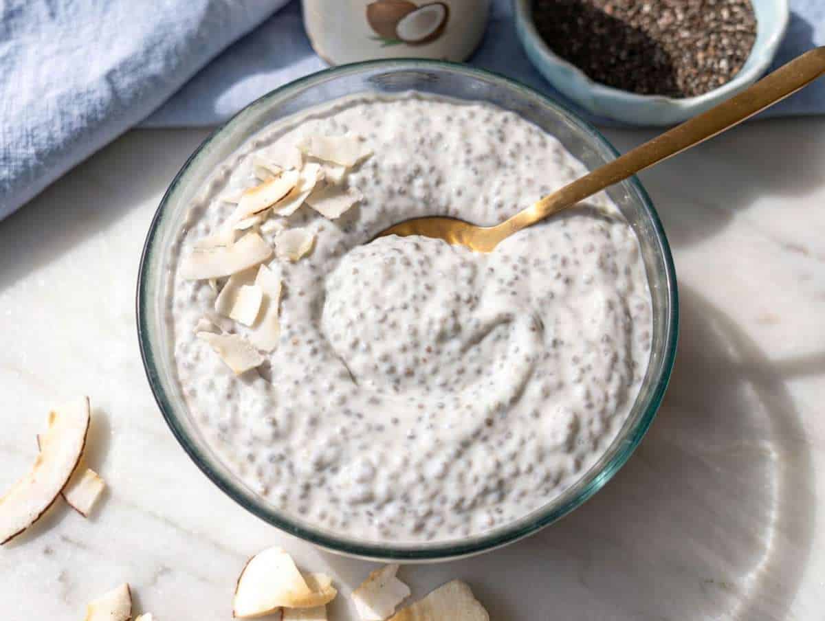 Step 4 Coconut chia pudding with thick creamy texture and spoon on marble surface.