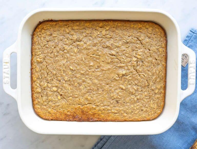 Step 4 Freshly baked oatmeal in pan with golden top resting on marble surface.