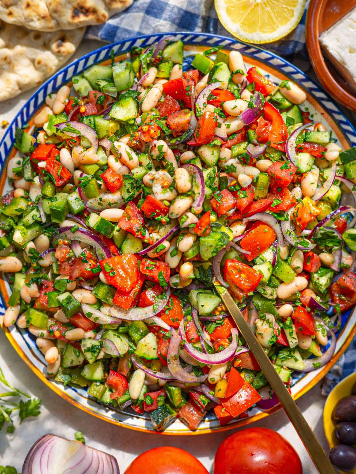 Turkish shepherdâs salad on a platter with tomatoes cucumber parsley and lemon dressing.