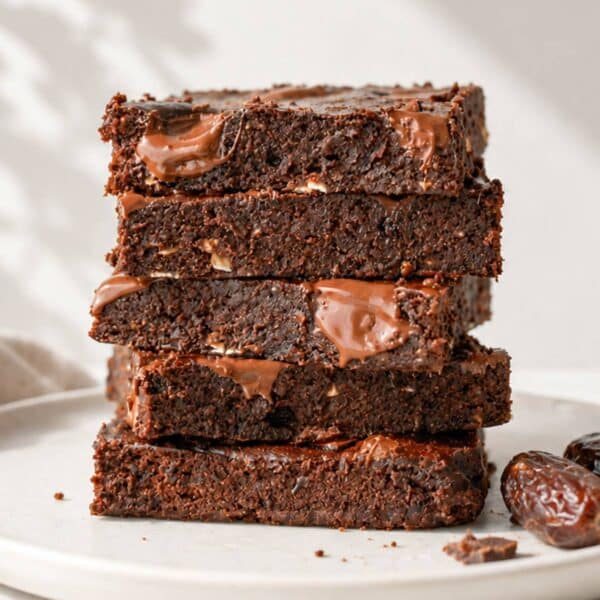 Date brownies stacked on marble with chocolate chips.