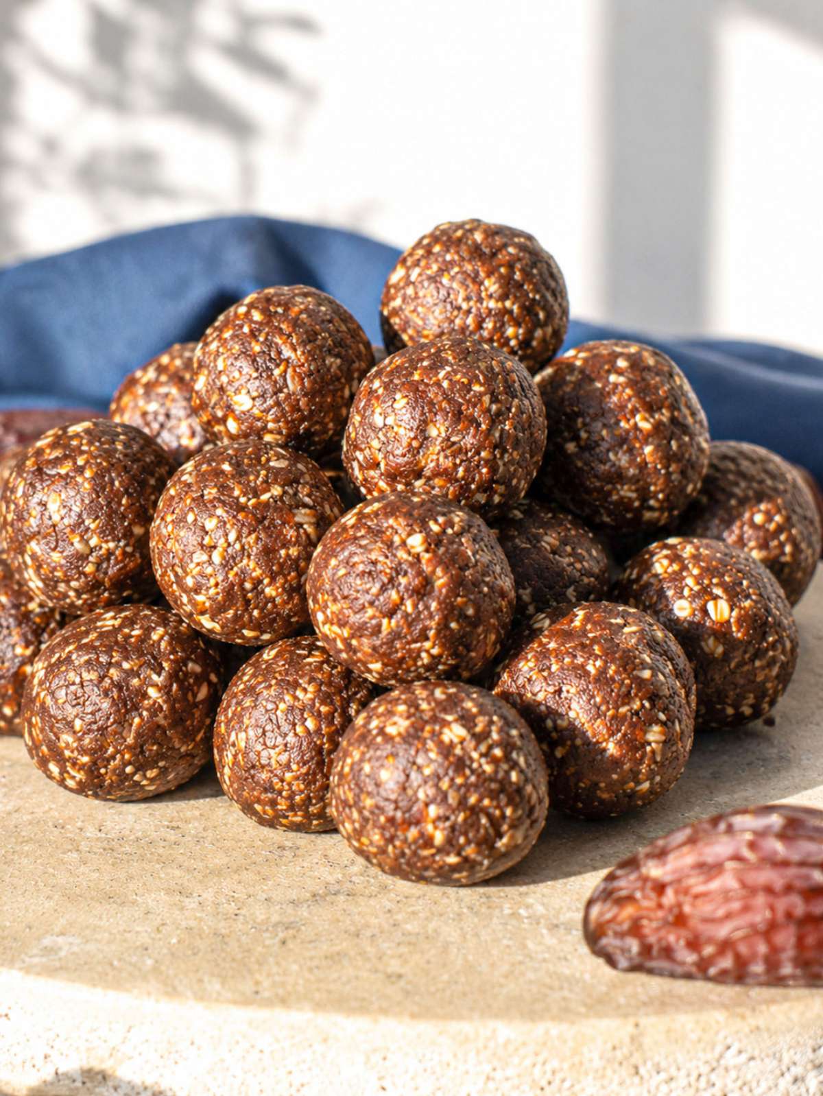 Date energy balls stacked on a small plate with natural window light.