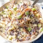 Fresh apple coleslaw with creamy yogurt dressing served in natural window light.