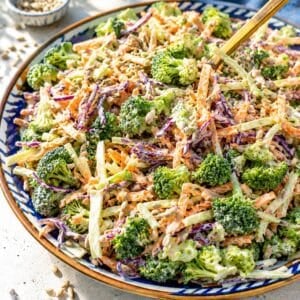 Healthy broccoli slaw served on a platter near a bright kitchen window.