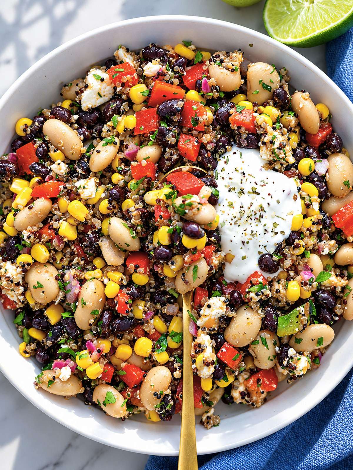 Mexican bean salad bowl with quinoa, beans, corn, and feta in ceramic bowl.