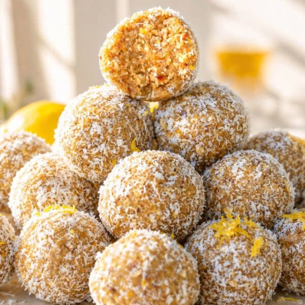 Stacked Lemon Energy Balls with scattered coconut and lemon zest.