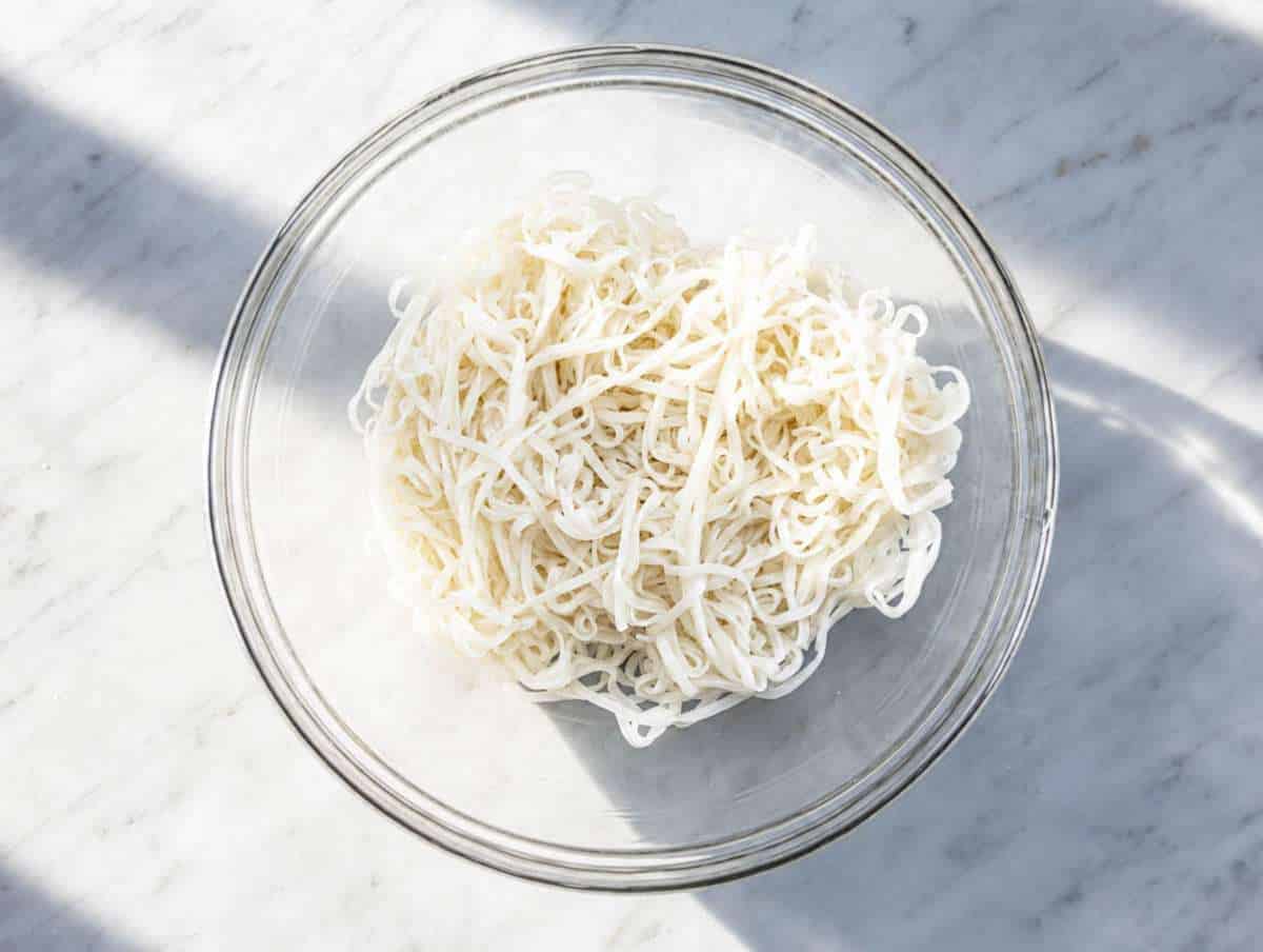 Step 1 Rice noodles in a large mixing bowl.