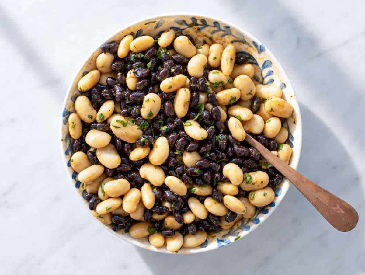 Step 2 Black beans and butter beans coated in smoky lime dressing inside mixing bowl.