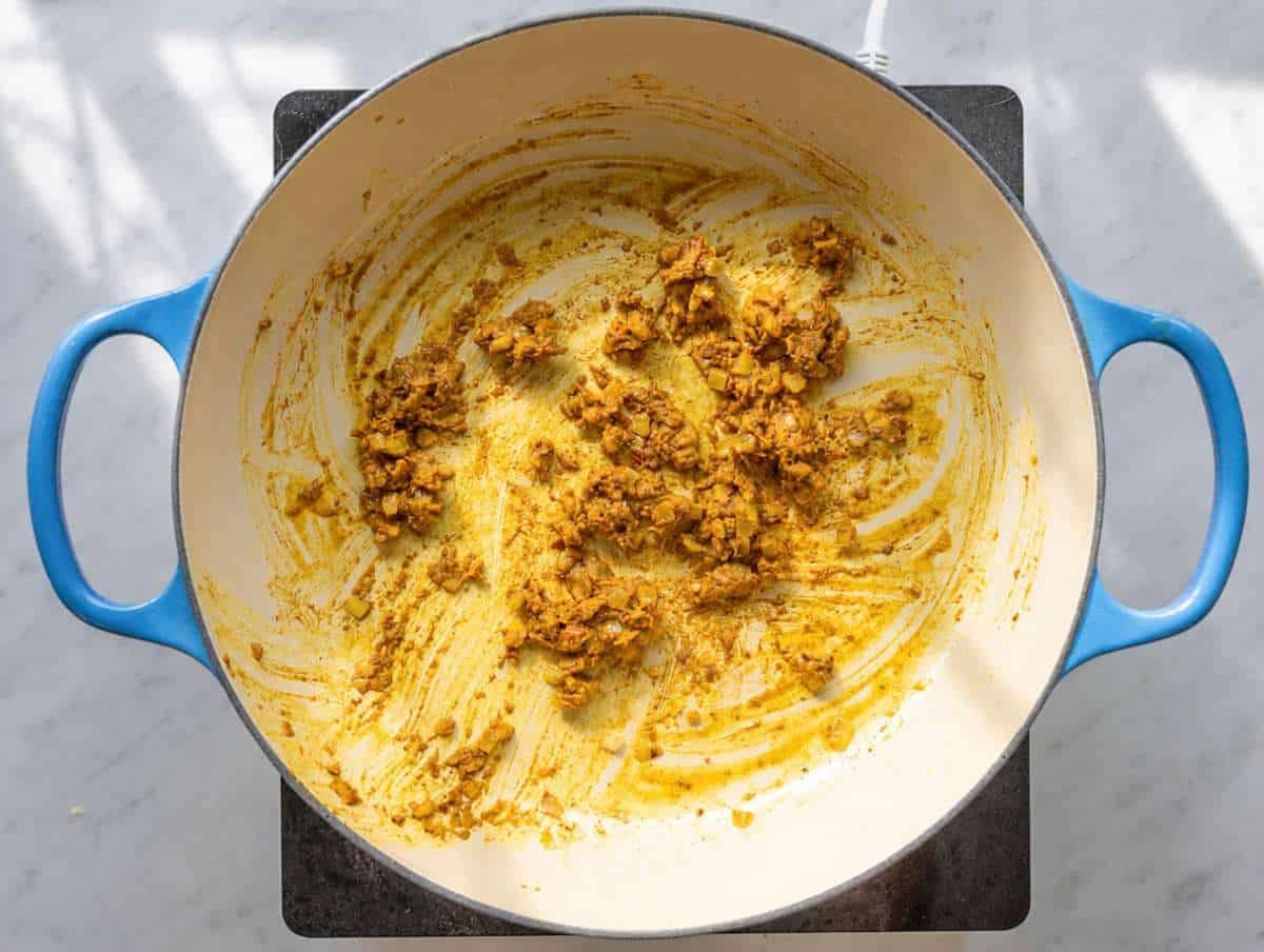 Step 2 Curry spices toasting in oil with onions and garlic in a warm skillet.