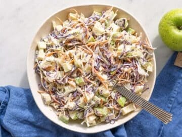 Step 3 Apple coleslaw tossed with creamy yogurt dressing in a large white bowl.