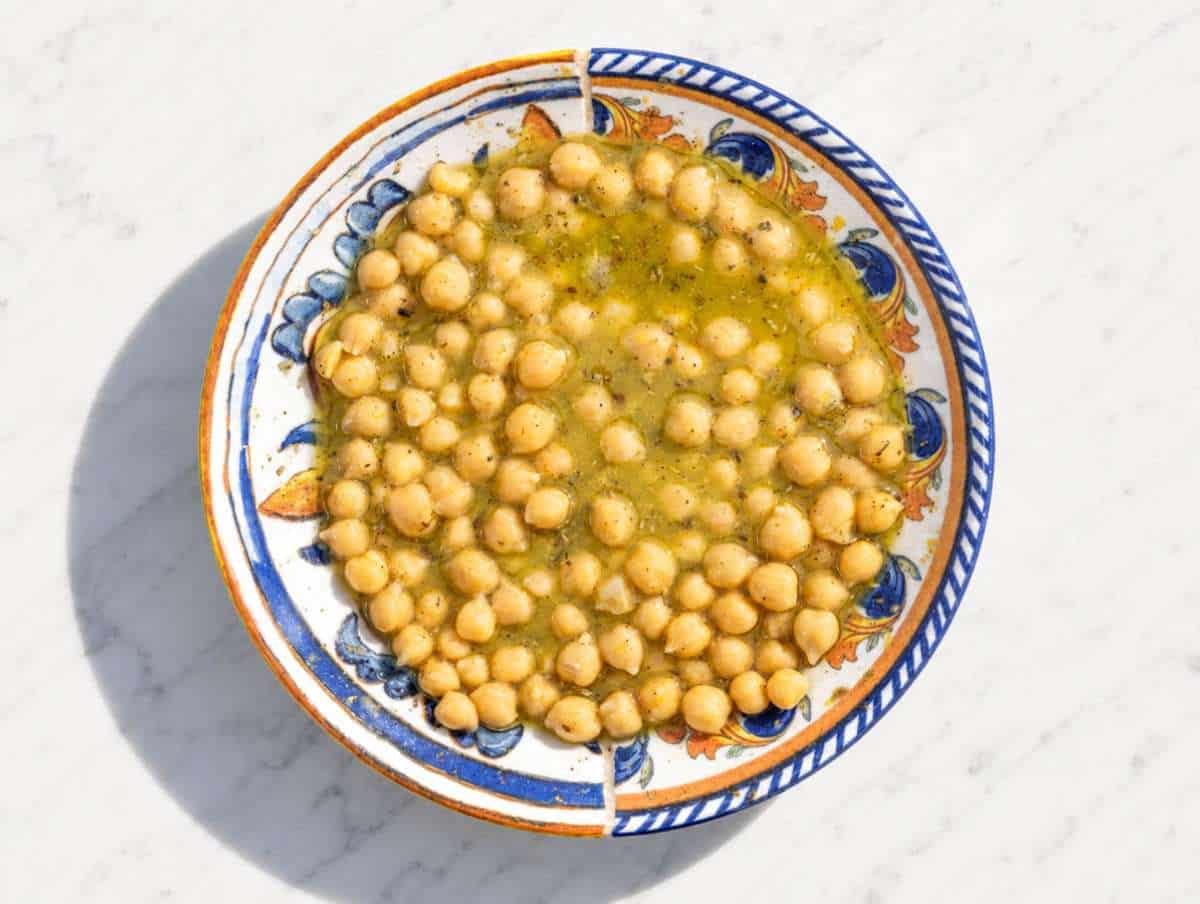 Step 3 Chickpeas marinating in lemon dressing with herbs and black pepper.