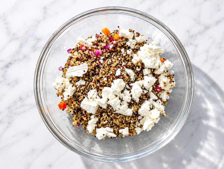 Step 3 Quinoa, corn, bell pepper, red onion, and feta layered in large salad bowl.