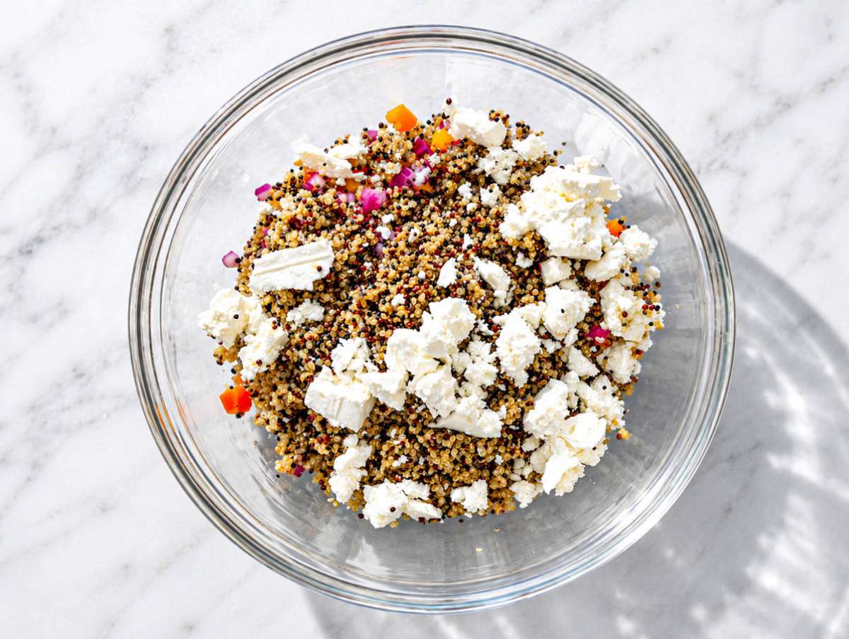 Step 3 Quinoa, corn, bell pepper, red onion, and feta layered in large salad bowl.