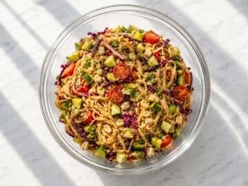 Step 4 Rice noodles tossed with cabbage, cucumber, tomatoes, cilantro, and peanuts.