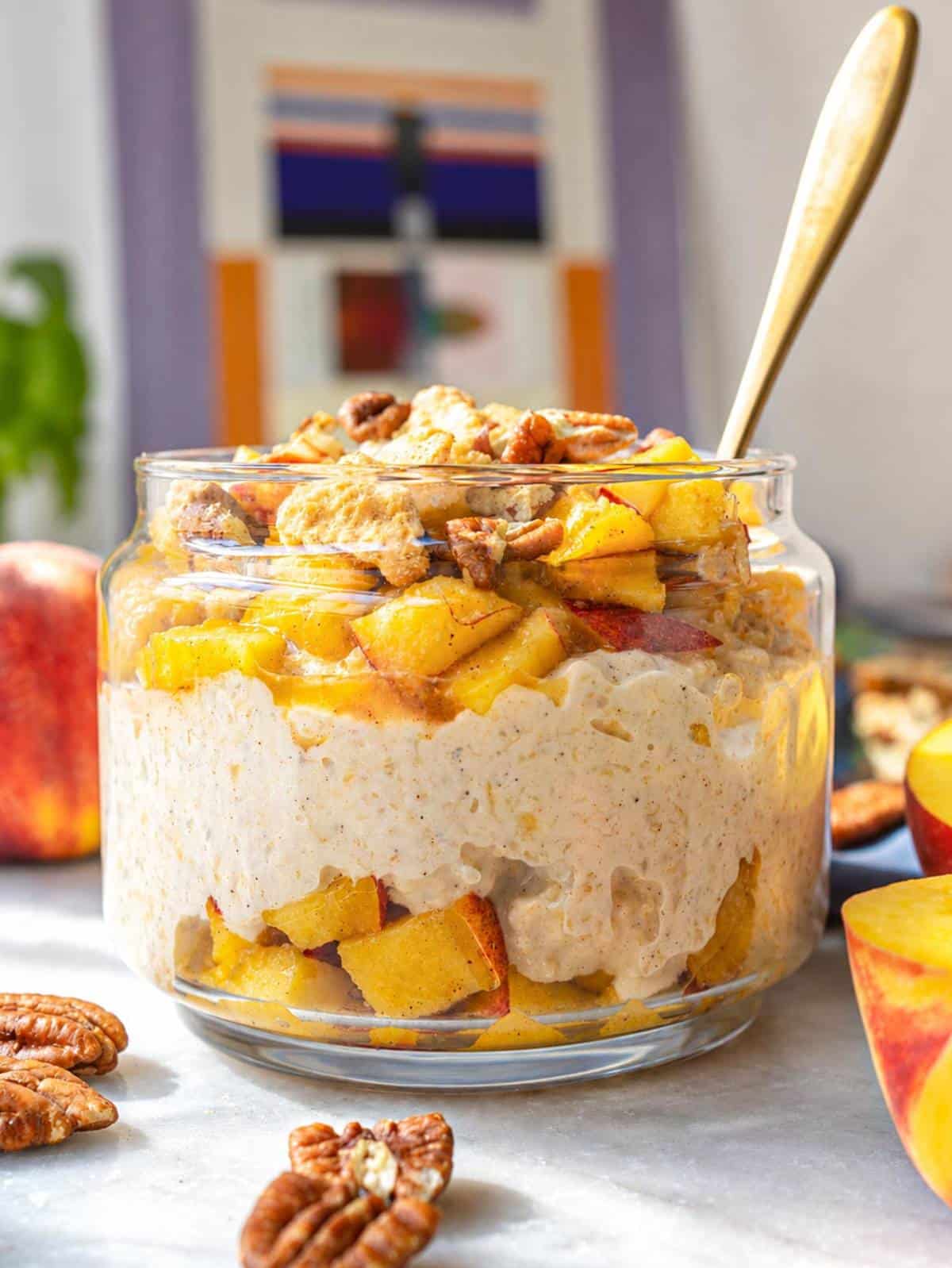 A jar of peach cobbler overnight oats with peach topping.
