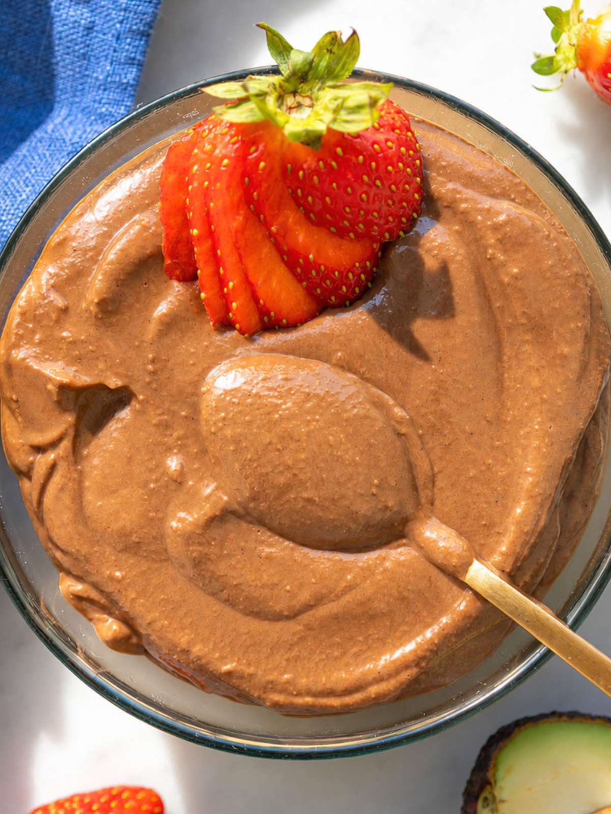 Avocado chocolate mousse in glass bowl with strawberry.