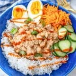 Close-up of creamy chickpeas over rice with crisp vegetables.