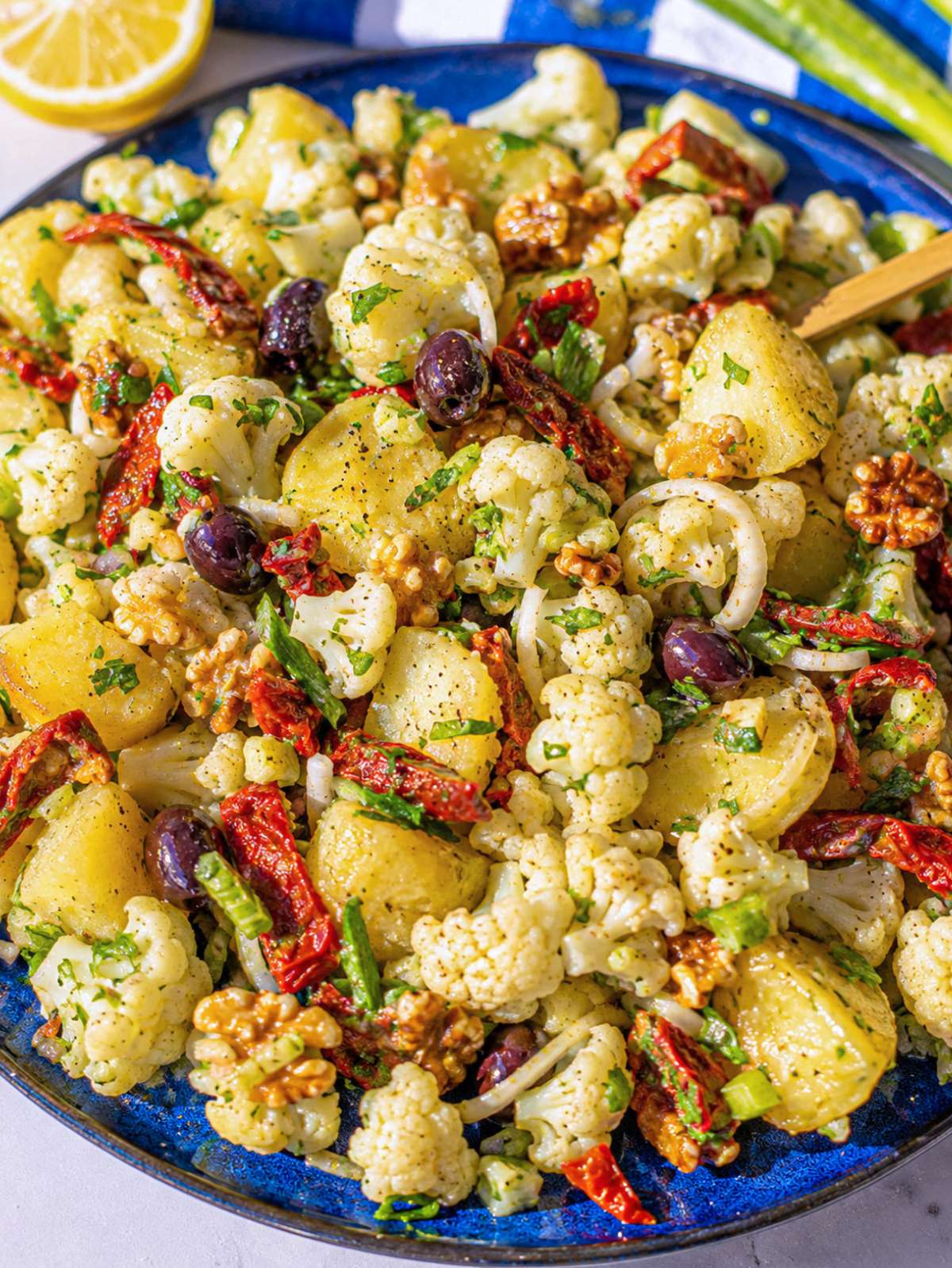 Close-up of creamy potatoes and cauliflower coated in bright lemon dressing.
