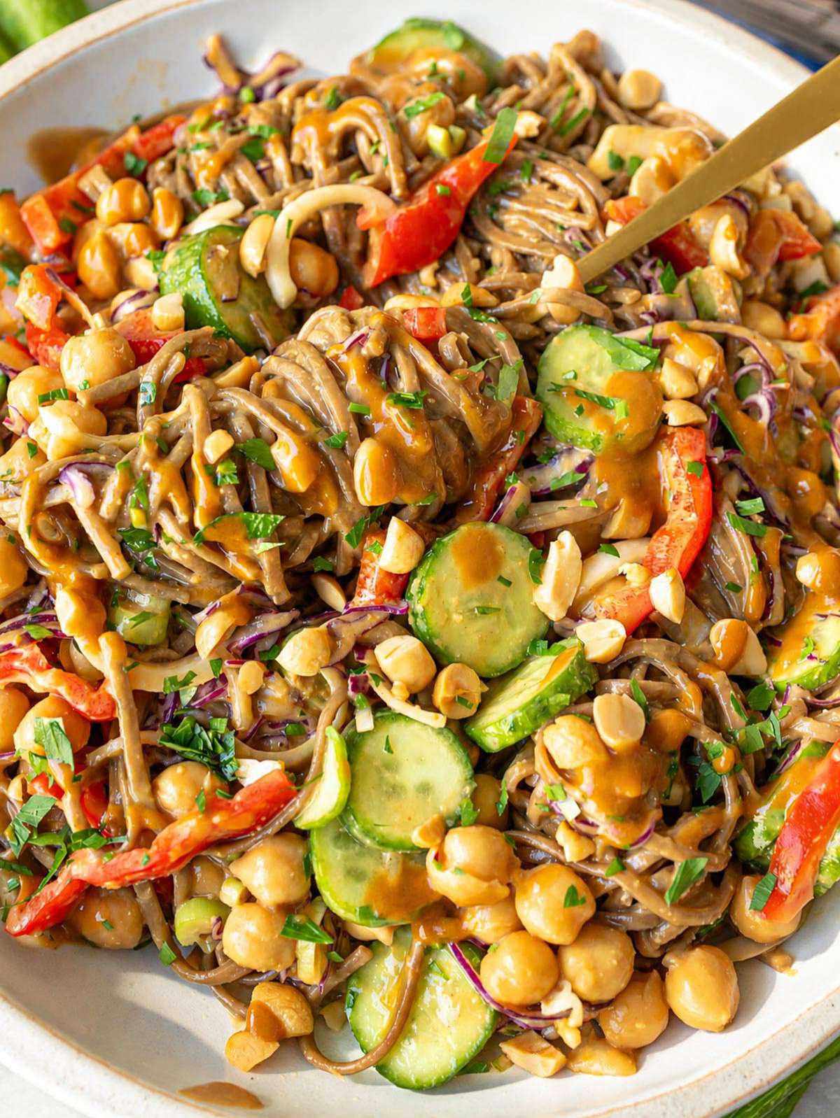 Close-up of peanut-coated soba noodles with crunchy vegetables.