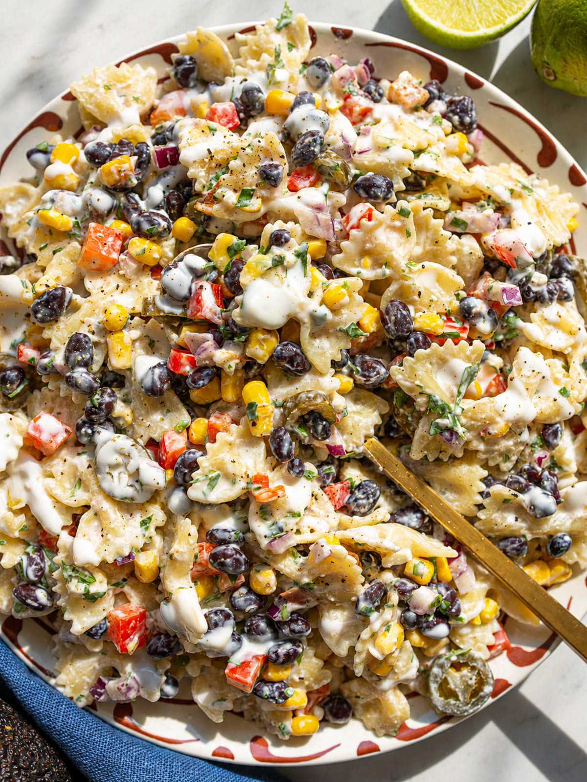Creamy Mexican pasta salad with black beans, corn, feta, and cilantro.