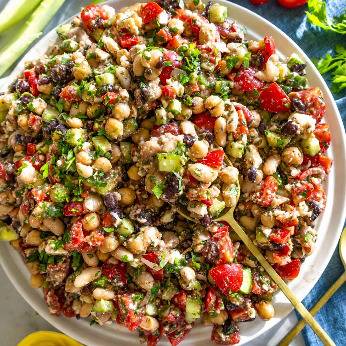 Dense bean salad on a plate with a spoon.