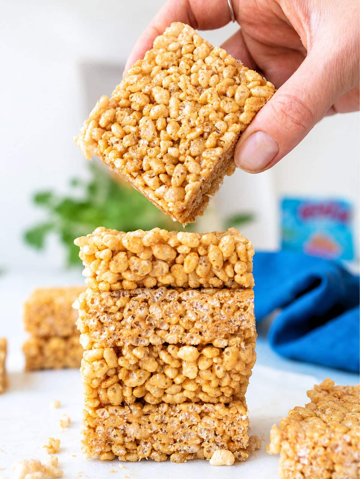Female hand and healthy Rice Krispie Treats showing crisp cereal.