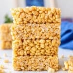 Healthy Rice Krispie Treats arranged on white marble in soft natural daylight.