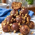 Homemade snickers energy balls on marble countertop.
