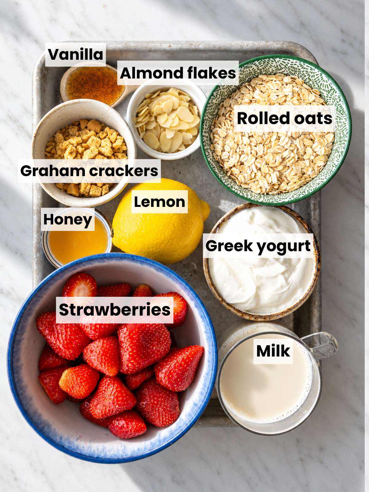 Ingredients for Strawberry Shortcake Overnight Oats on a white marble countertop.