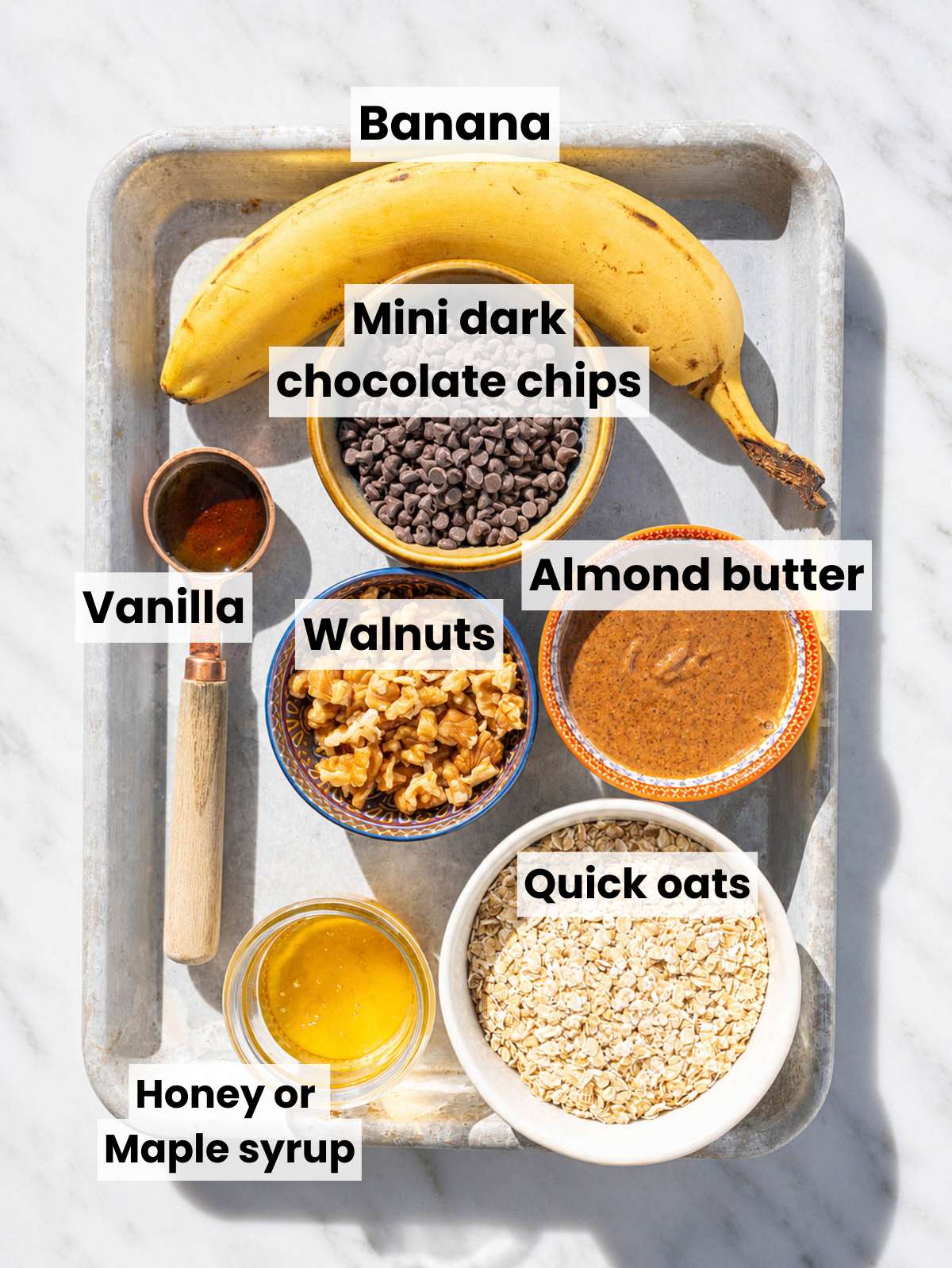 Ingredients for chunky monkey energy balls on marble surface.