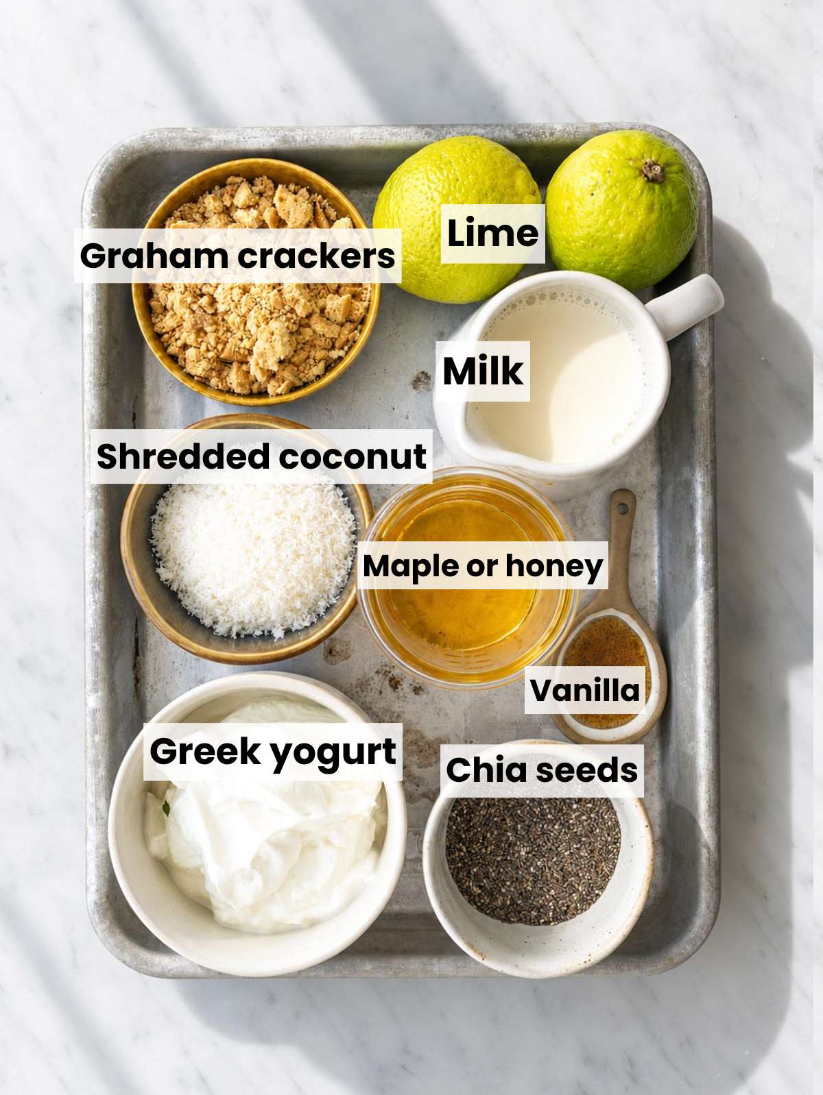 Ingredients for key lime pie chia pudding on marble countertop.