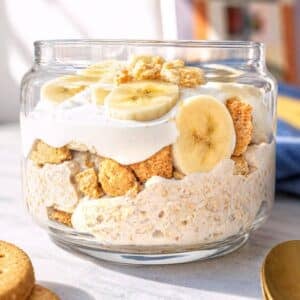 Jar of banana pudding overnight oats in natural window light.