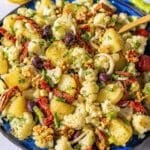 Mediterranean potato cauliflower salad served in a rustic bowl near a sunny window.