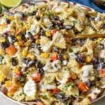 Mexican pasta salad in a white serving bowl on a marble countertop.